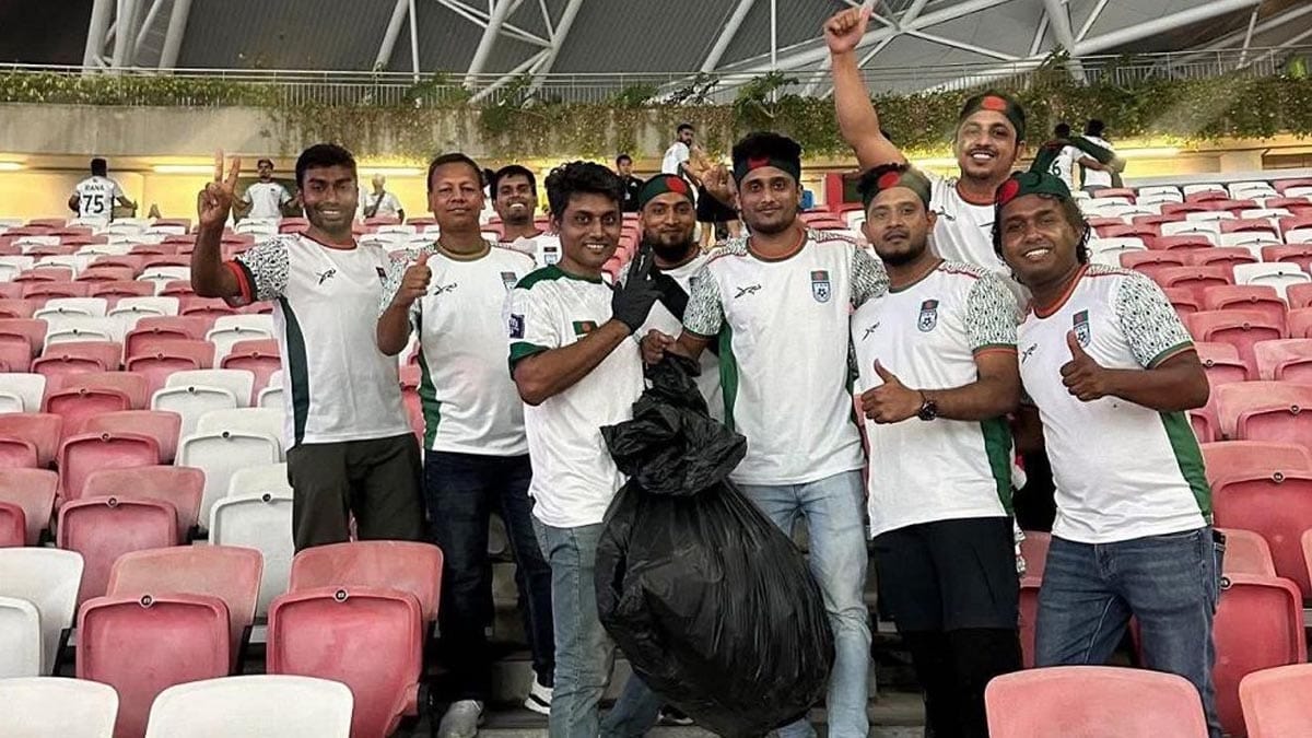সিঙ্গাপুর জাতীয় স্টেডিয়ামে ম্যাচ শেষে গ্যালারির আবর্জনা পরিষ্কার করছেন বাংলাদেশি ফুটবল সমর্থকরা।