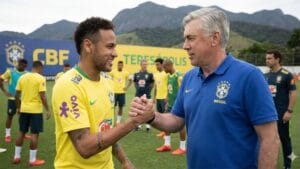 Brazil forward Neymar smiling in the yellow jersey during meeting with Ancelotti.