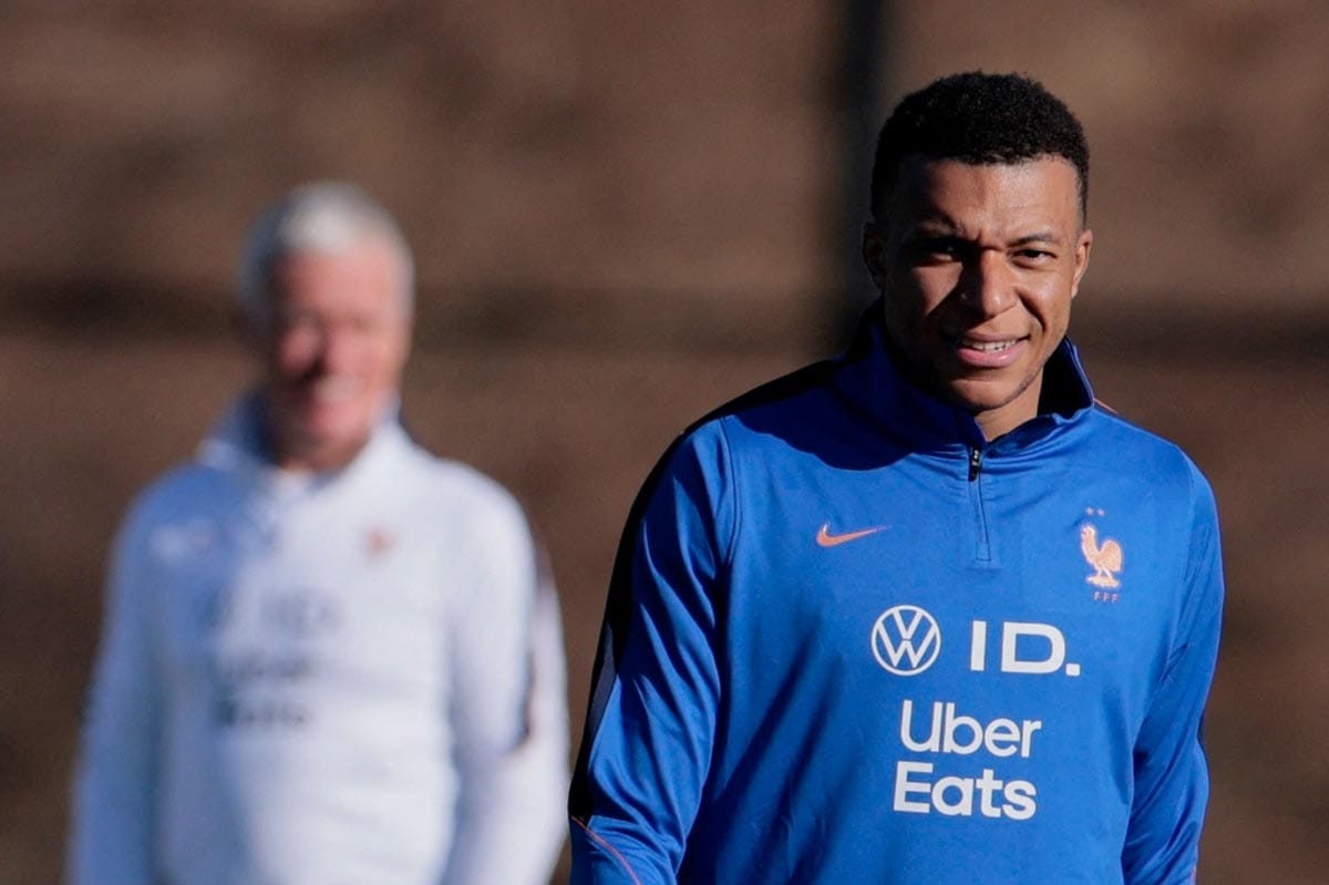 Kylian Mbappe wearing the French national team training kit and smiling.